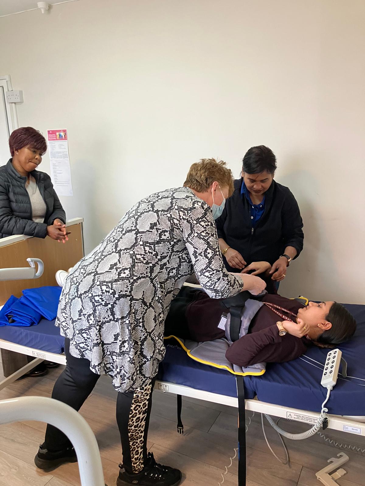 Care training session with a patient on a hospital bed