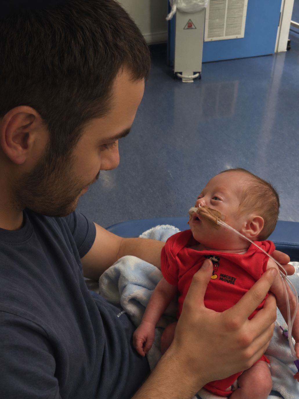 A father holding his newborn daughter in hospital.